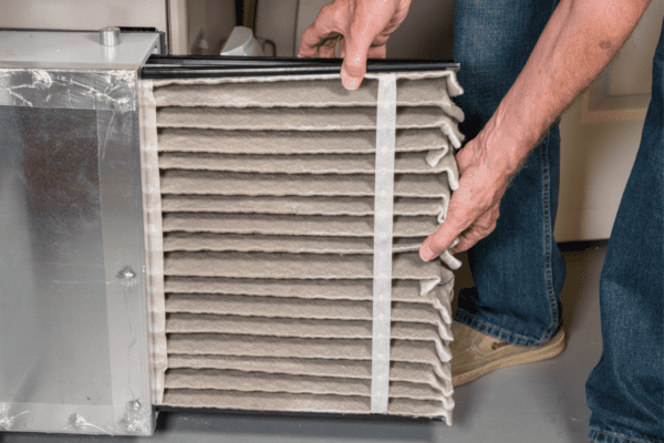 A person is holding an air filter in their hand.