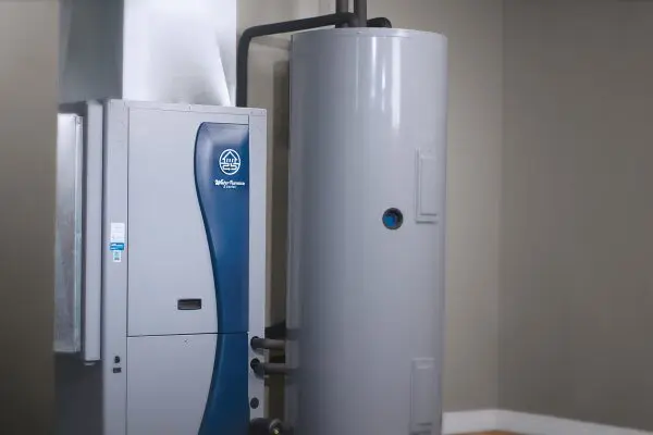 A large white water heater next to a blue and white machine.