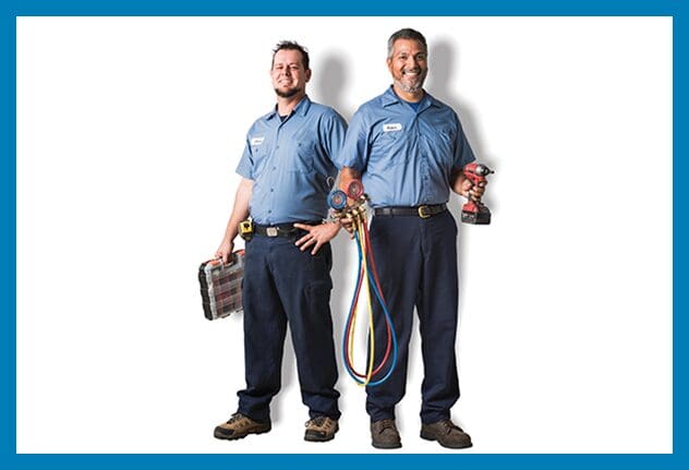 Two men standing next to each other holding a hose.